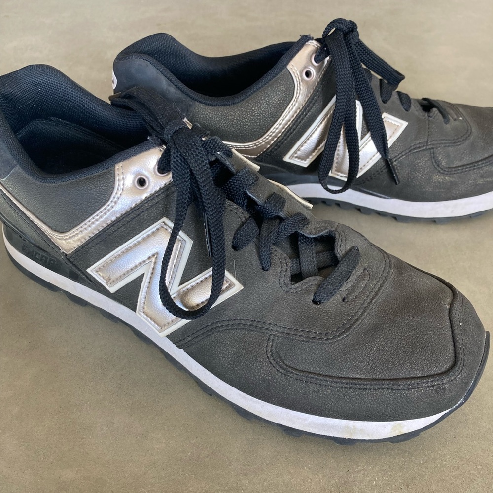 Black and gold New Balance tennis shoes